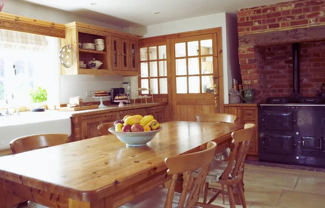 Cuisine rustique en pin, grande table en bois et mur de briques